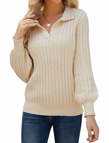 Woman wearing beige cable knit sweater with jeans.