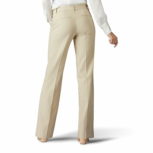 Back view of beige women's trousers worn with white blouse