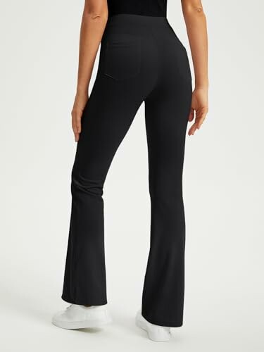 Person wearing black flare leg pants and white sneakers.