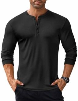 Man wearing a black long-sleeve Henley shirt with hands in pockets.