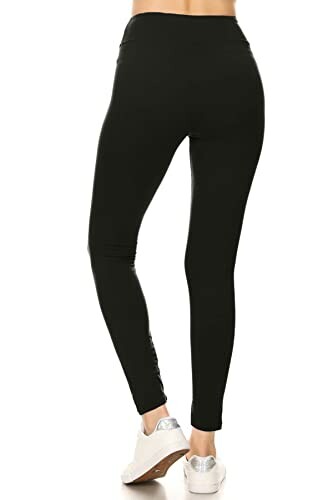 Back view of person wearing black leggings and white sneakers.