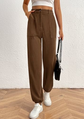 Person wearing brown high-waisted pants and white sneakers.