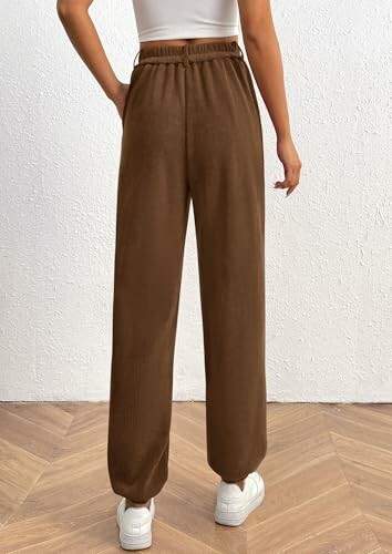 Person wearing brown wide-leg pants and white sneakers