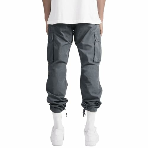 Person wearing grey cargo pants with drawstring cuffs.