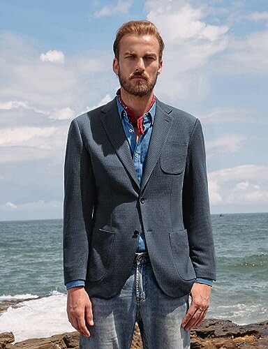 Man in blazer standing by the sea