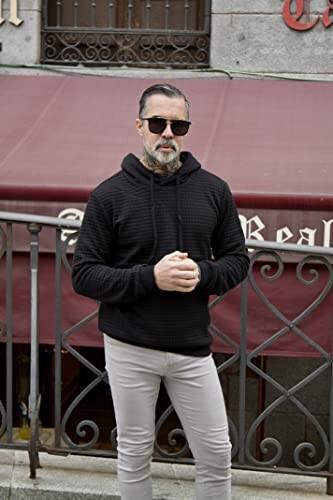 Man in sunglasses and hoodie standing outside