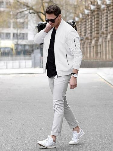 Man in white jacket and pants walking on street
