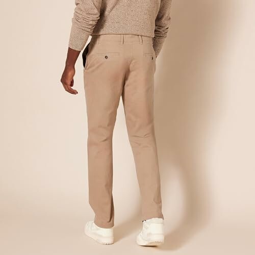 Back view of a man wearing beige pants and white shoes