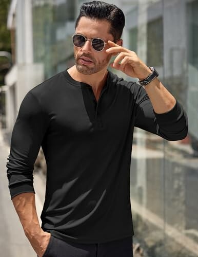 Man wearing a black long-sleeve shirt and sunglasses.