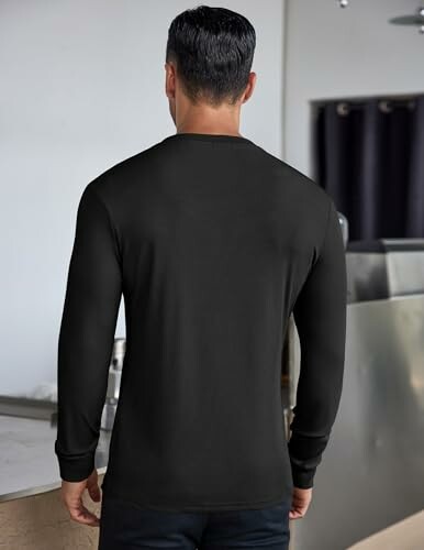 Man wearing a black long-sleeve shirt, back view