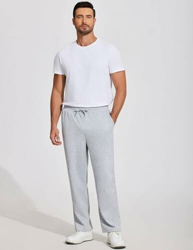 Man in white t-shirt and gray sweatpants.