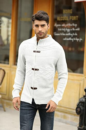 Man wearing a white knitted cardigan with toggle buttons.