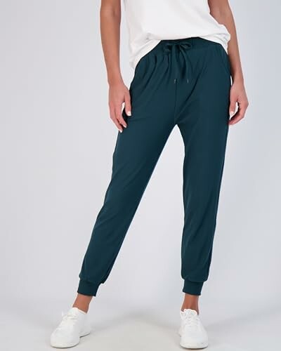 Person wearing navy jogger pants and white sneakers