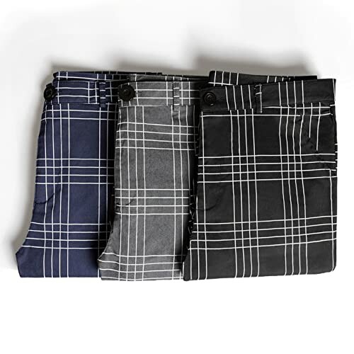 Three folded plaid pants in navy, gray, and black.