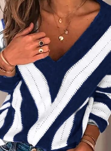 Person wearing a blue and white striped V-neck sweater with jewelry