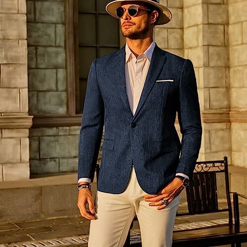 Man in blue suit and sunglasses standing outdoors
