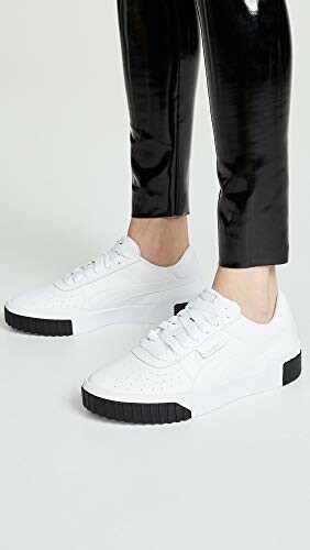 Person wearing white sneakers and black pants