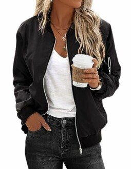 Woman wearing a black bomber jacket, white shirt, and holding a coffee cup.