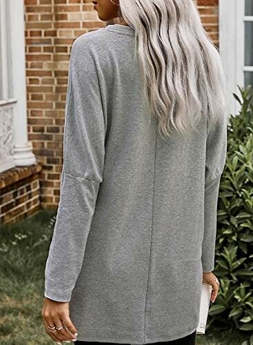 Woman in gray cardigan standing outdoors