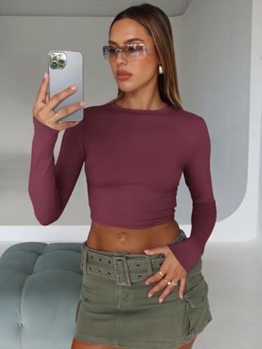Woman in maroon top and green skirt taking a selfie