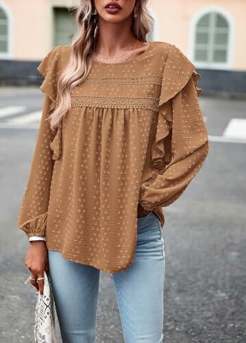 Woman in brown blouse and jeans standing outdoors